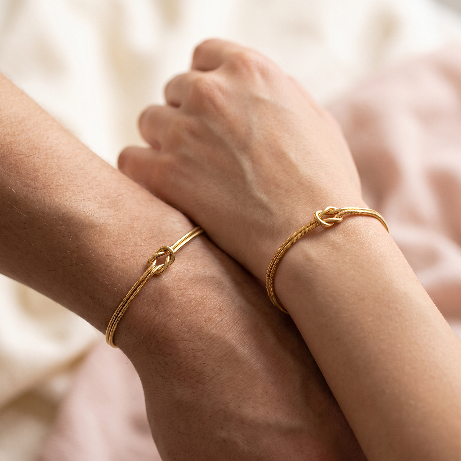 Two matching Forever Knot bracelets worn on two wrists side by side
